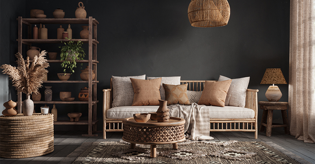 Ein mit dunkler Kalkfarbe gestrichener Raum, eingerichtet mit natürlichen Rattan-Möbeln in warmen Erdtönen.